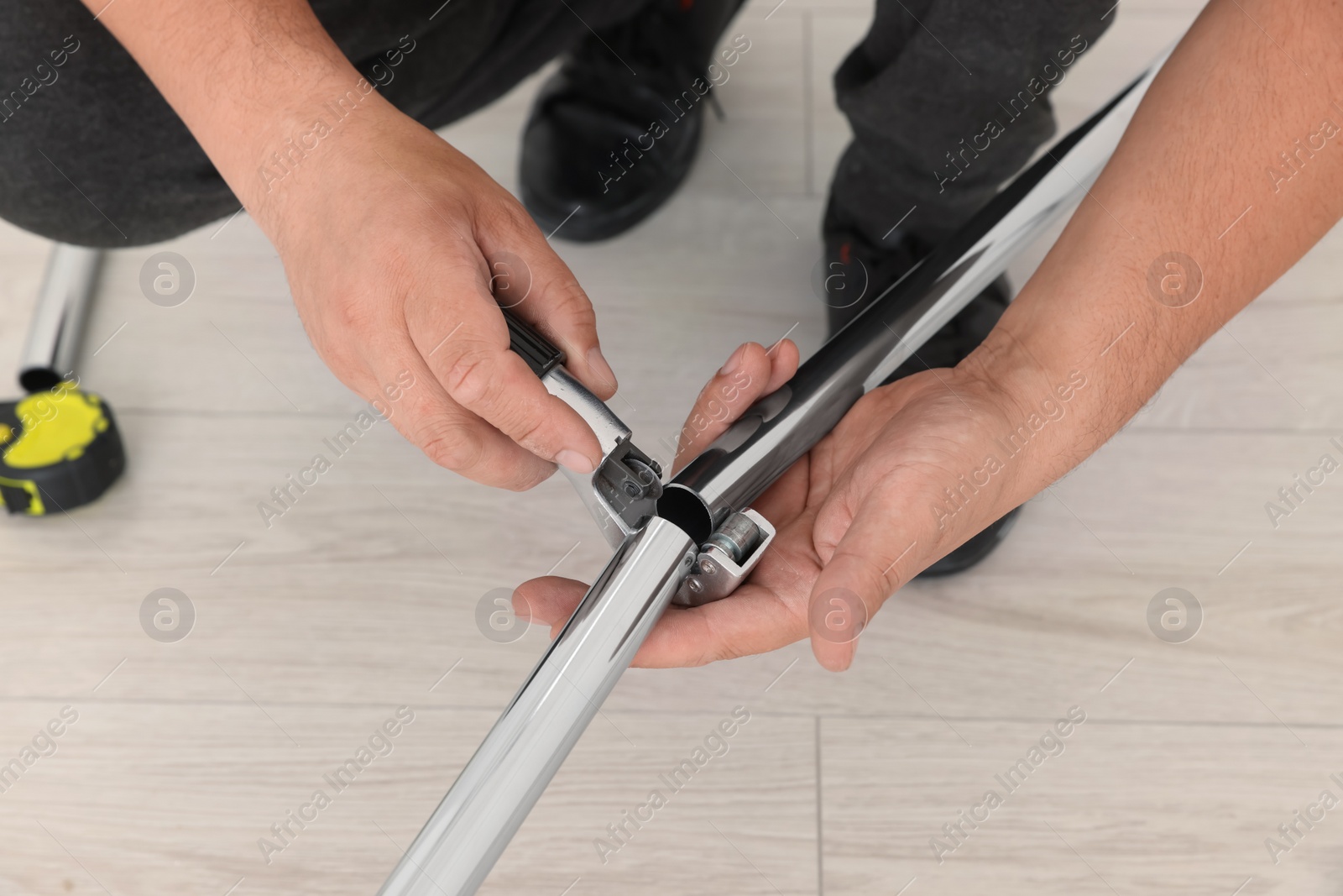 Photo of Worker installing new metal pipes indoors, closeup