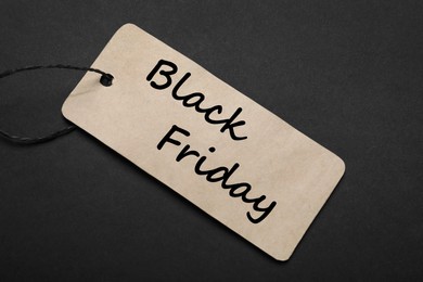 Black Friday tag on color background, top view