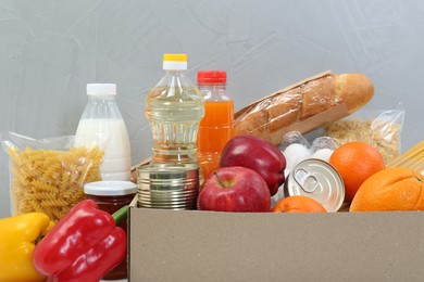 Humanitarian aid. Different food products for donation on grey background, closeup