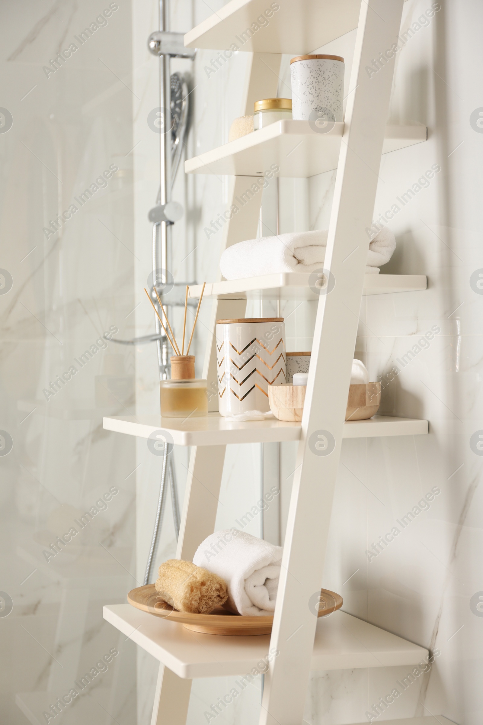 Photo of Shelving unit with different items in bathroom interior