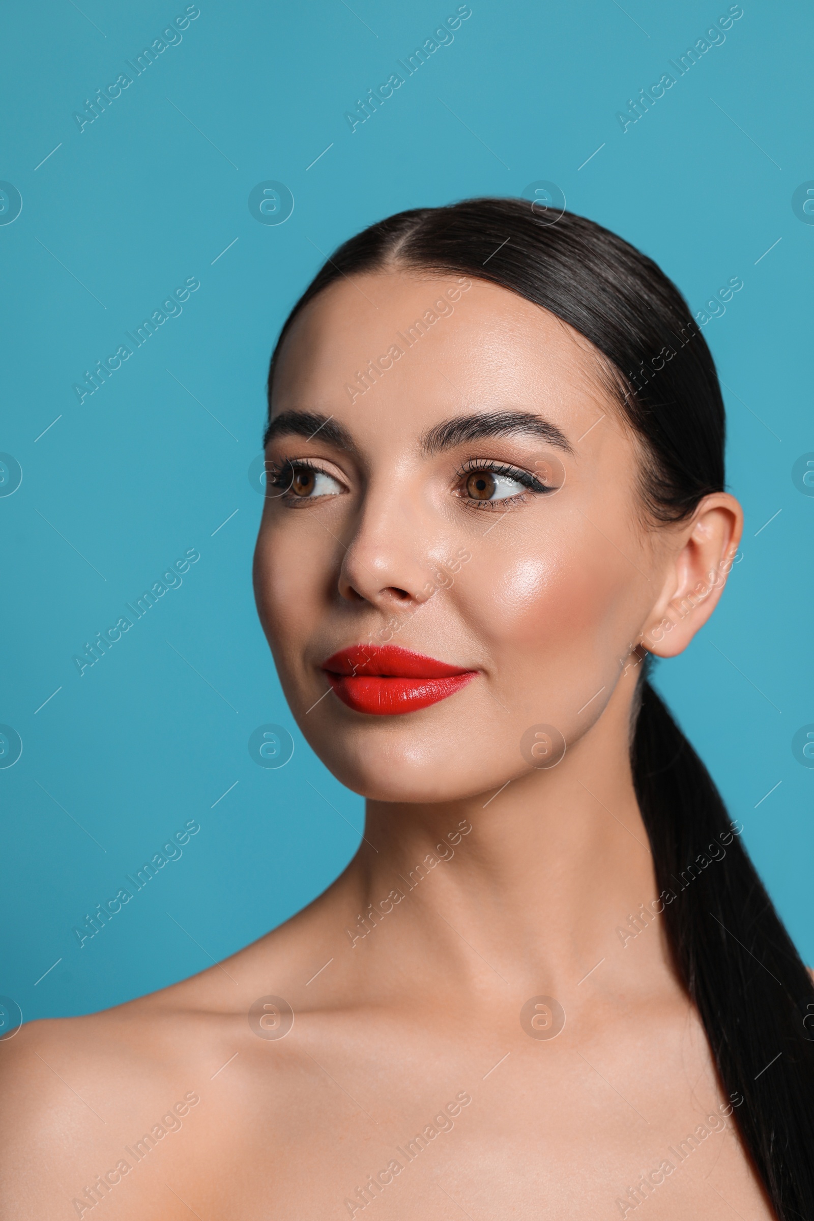 Photo of Attractive smiling woman against light blue background