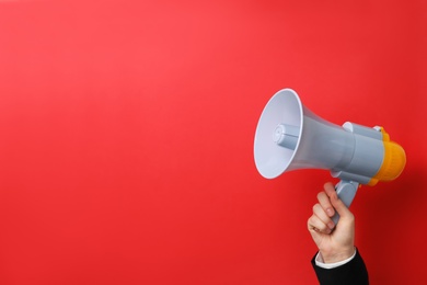 Man holding megaphone on color background