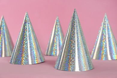 Photo of Beautiful silver party hats on pink background