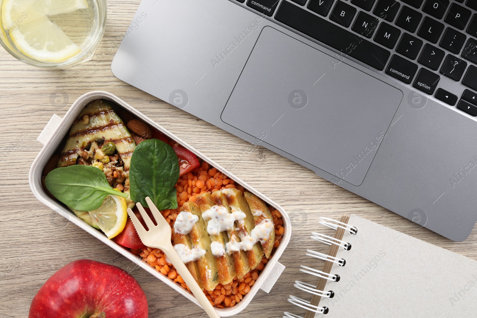 Photo of Healthy products high in vegetable fats near laptop on wooden table, flat lay