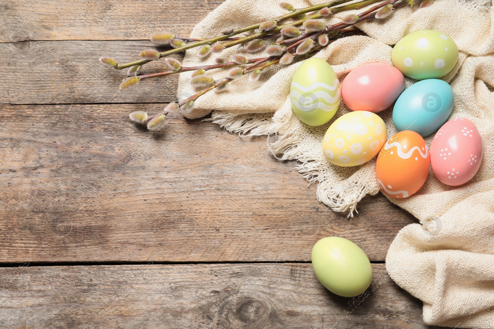 Photo of Flat lay composition with colorful painted Easter eggs on wooden table, space for text