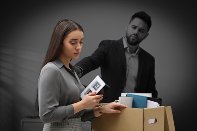 Image of Colleague comforting dismissed young woman in office