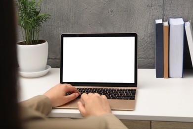 Woman working on laptop at white table, closeup. Mockup for design