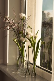 Different beautiful spring flowers on windowsill indoors