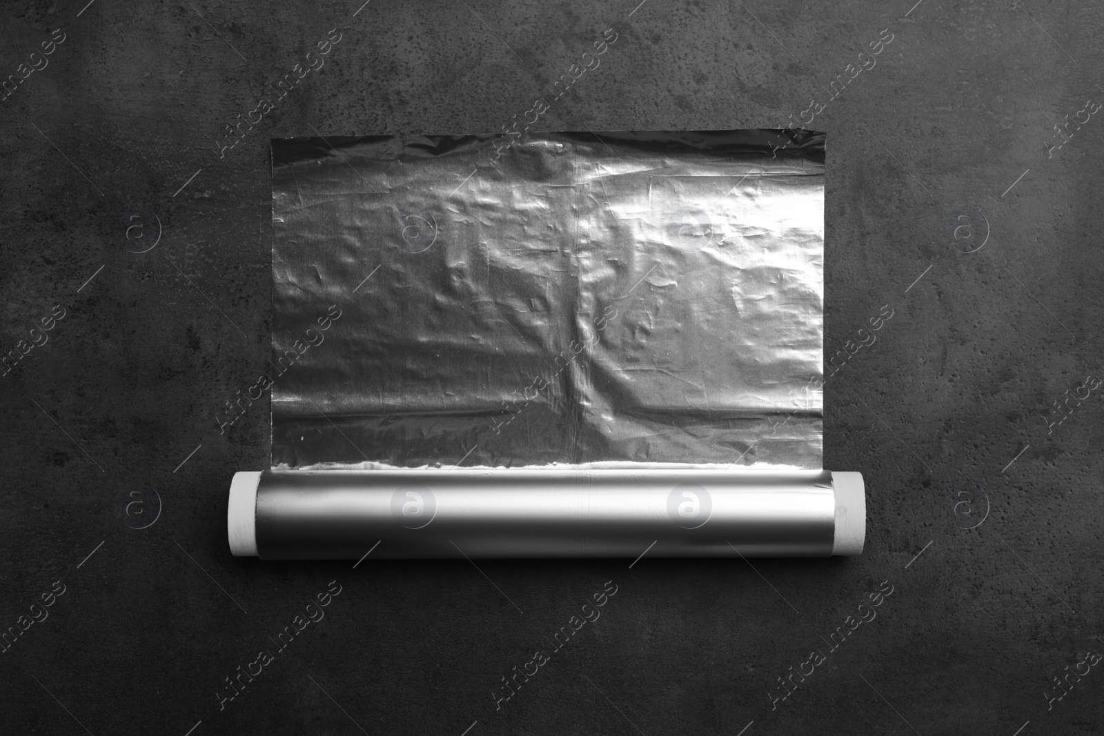 Photo of Roll of foil paper on grey table, top view