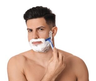 Handsome man shaving with razor on white background