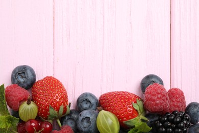 Photo of Mix of different fresh berries and mint on pink wooden table, flat lay. Space for text