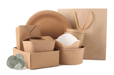 Photo of Eco friendly food packagings, disposable plate, paper bag and eucalyptus leaves isolated on white