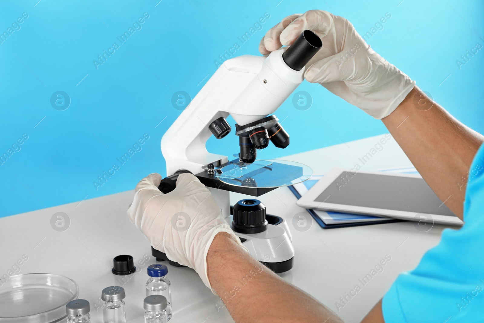 Photo of Male doctor using microscope at table, closeup. Medical object