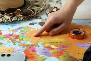 Photo of Woman with world map at table, closeup. Travel during summer vacation