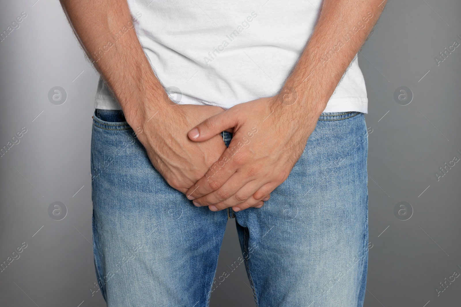 Photo of Man suffering from genital herpes on grey background, closeup