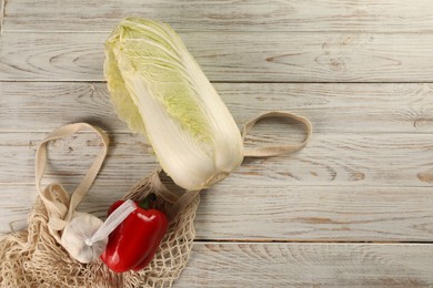 Photo of Fresh Chinese cabbage, bell pepper and garlic on wooden table, flat lay. Space for text