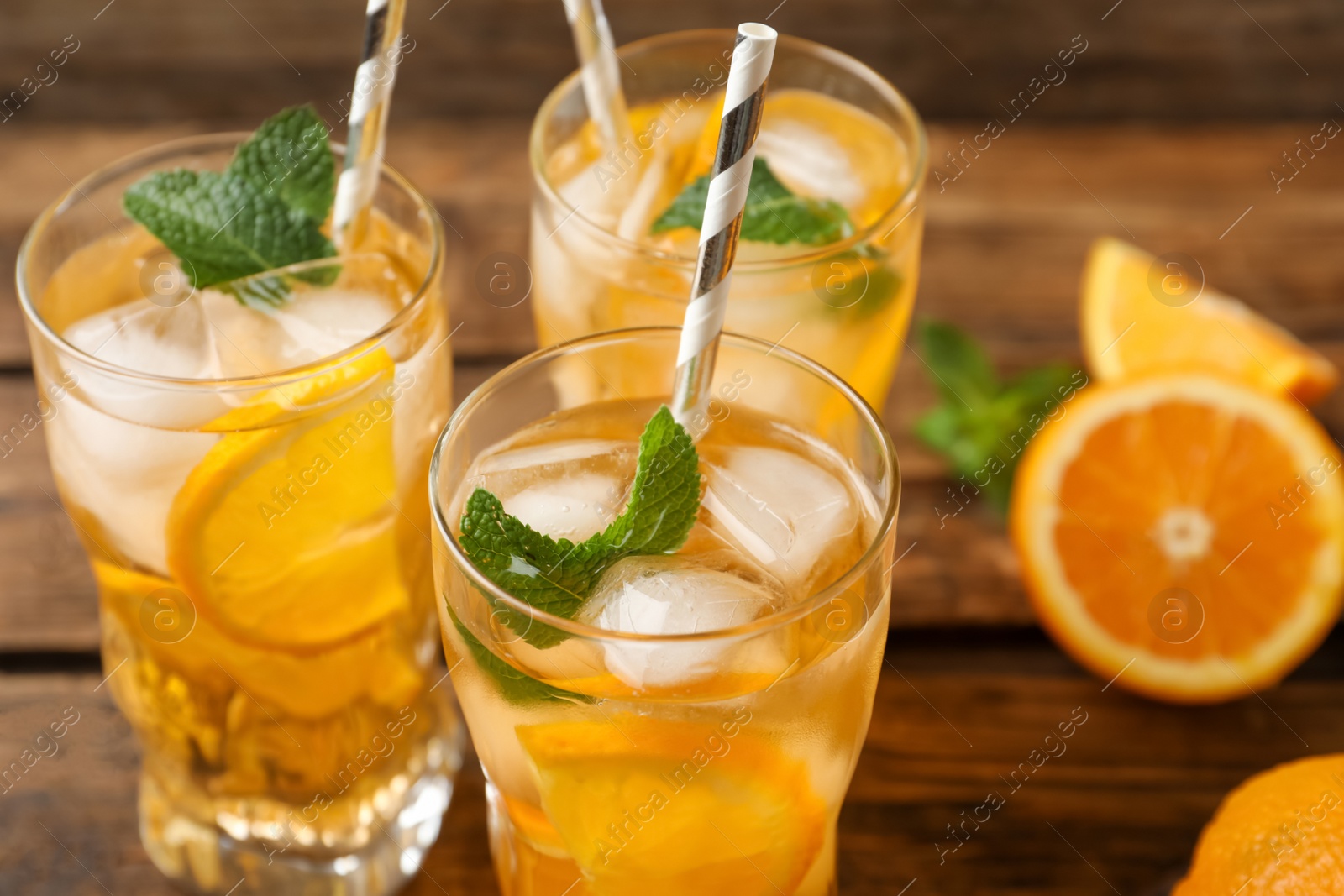 Photo of Delicious refreshing drink with orange slices on table, closeup