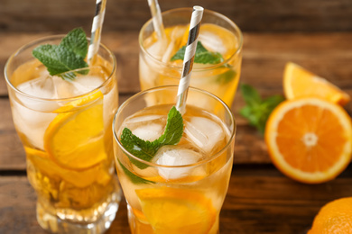 Delicious refreshing drink with orange slices on table, closeup