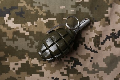 Photo of Hand grenade on digital camouflage fabric, top view
