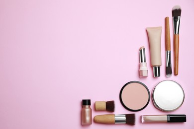 Photo of Face powders and other decorative cosmetic products on pink background, flat lay. Space for text
