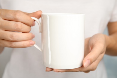 Photo of Woman holding ceramic cup, closeup. Mock up for design