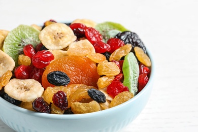 Photo of Bowl with different dried fruits on wooden background, closeup. Healthy lifestyle