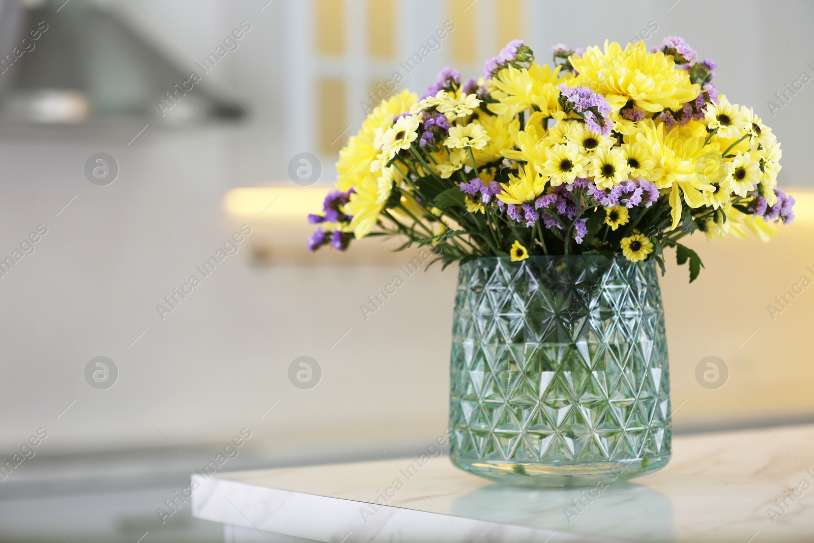 Photo of Vase with beautiful chrysanthemum flowers on table in kitchen, space for text. Interior design