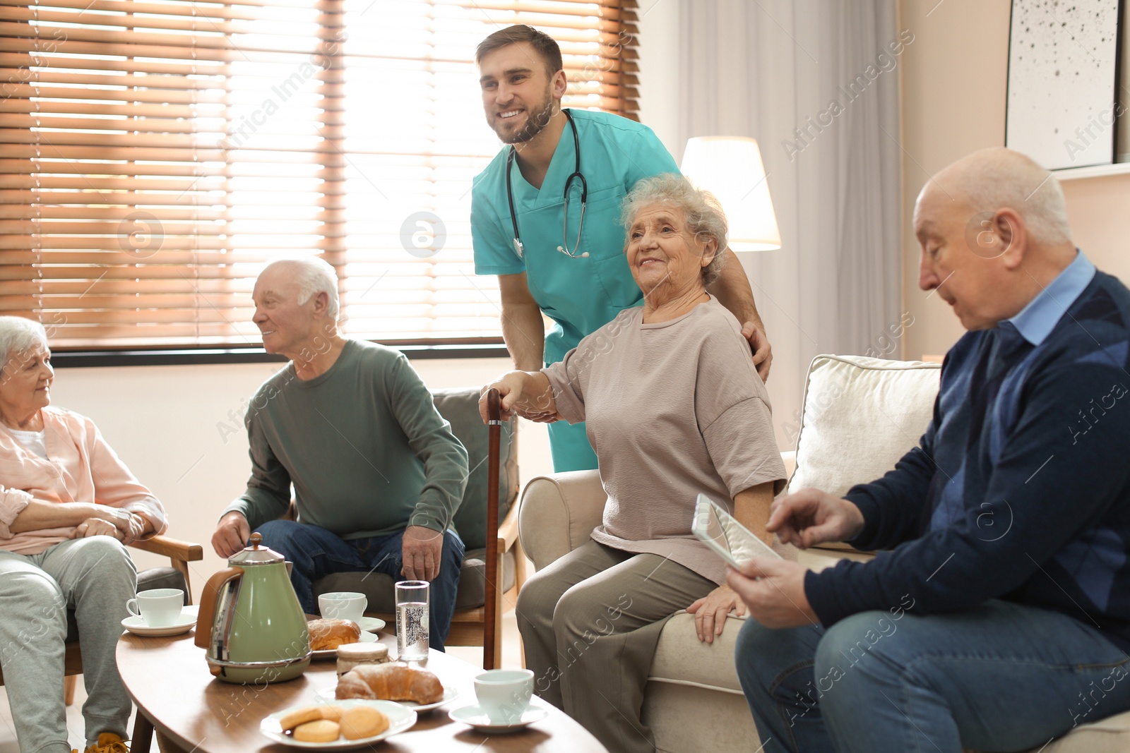 Photo of Medical worker taking care of elderly woman in geriatric hospice