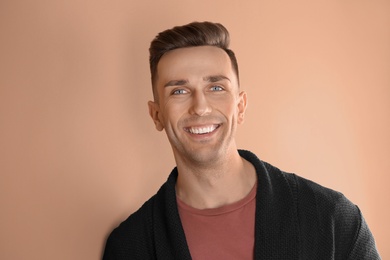 Portrait of young man with beautiful hair on color background