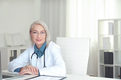 Photo of Portrait of mature female doctor in white coat at workplace