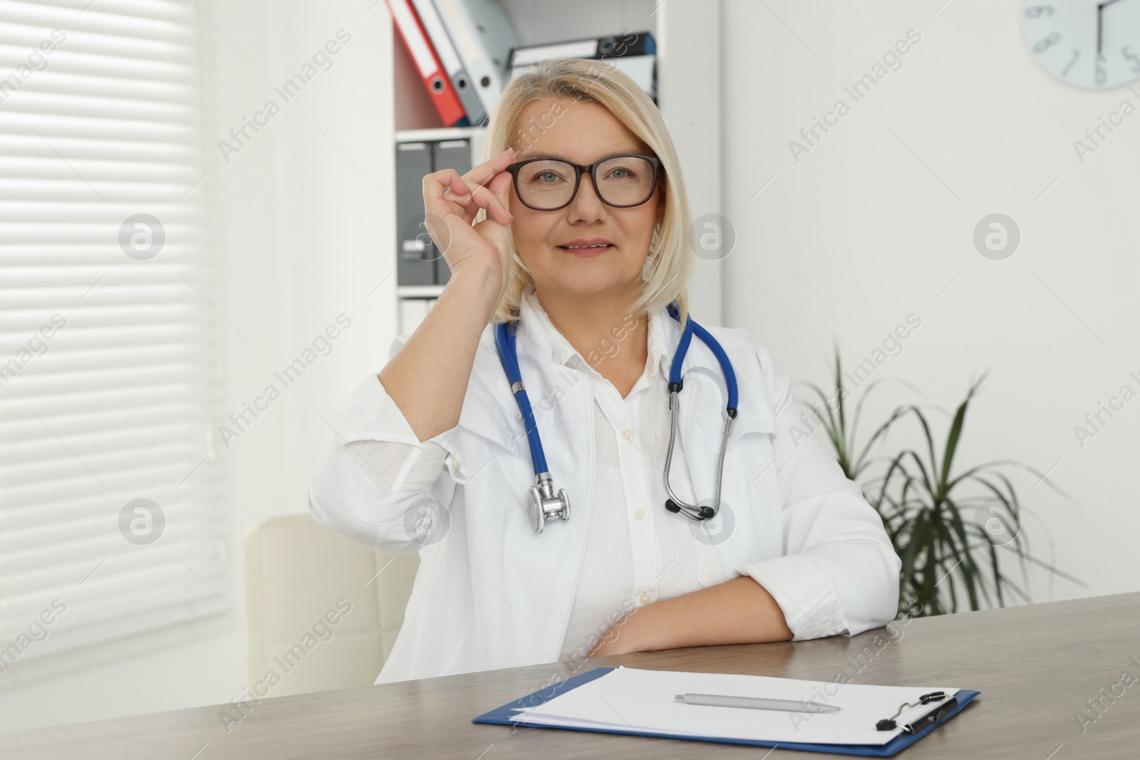 Photo of Doctor sitting at wooden table in clinic