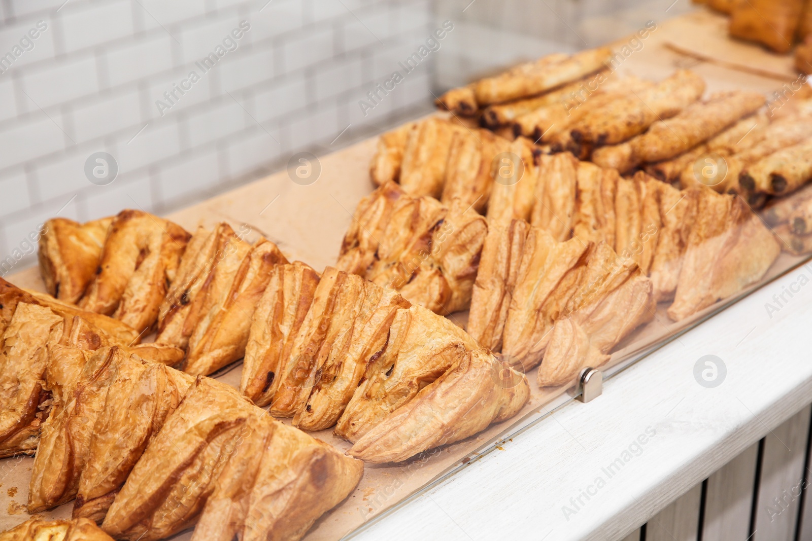 Photo of Fresh pastries on counter in bakery store. Space for text