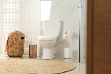 Photo of Toilet bowl near shower stall in modern bathroom interior