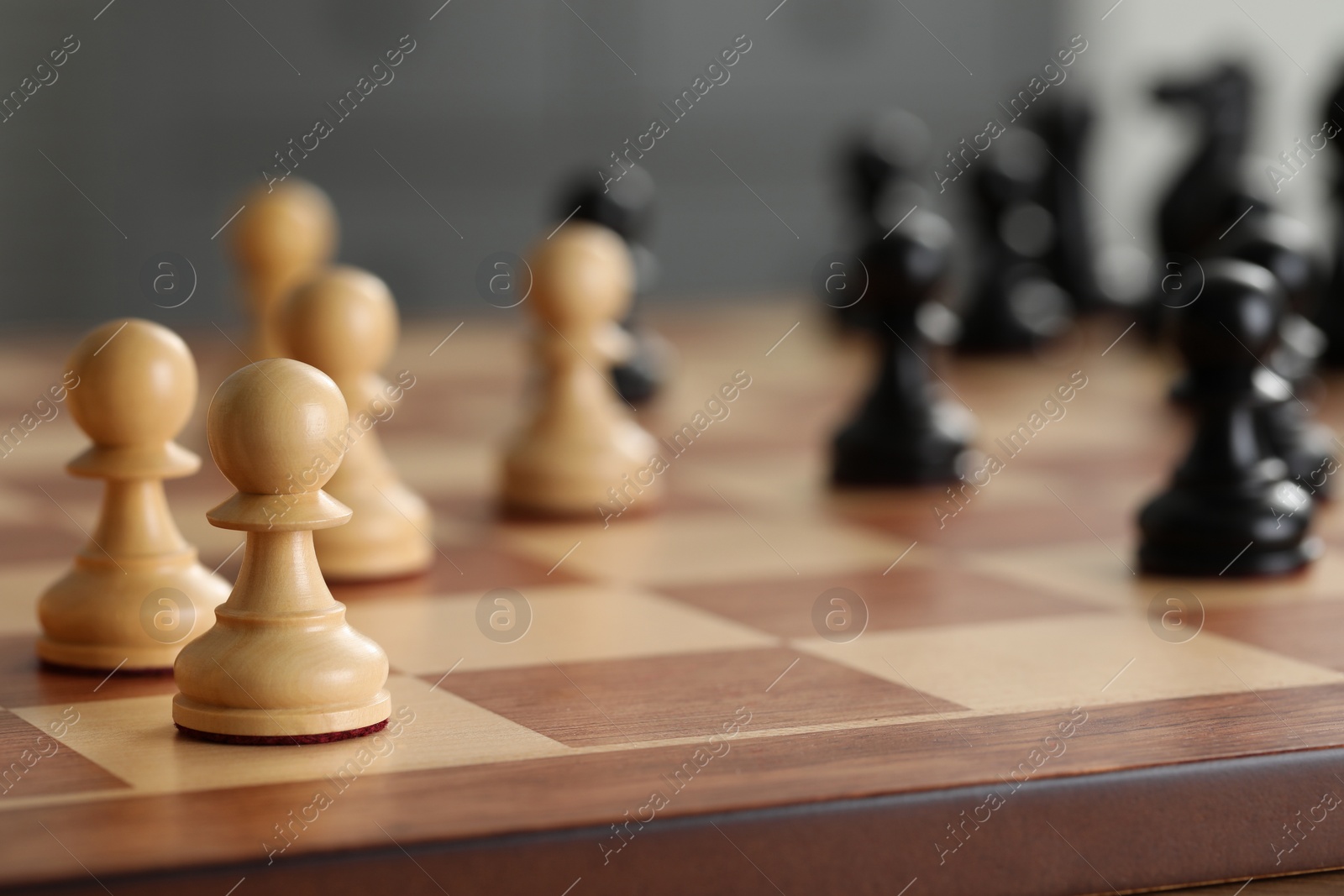 Photo of White wooden pawns on chess board, selective focus. Space for text