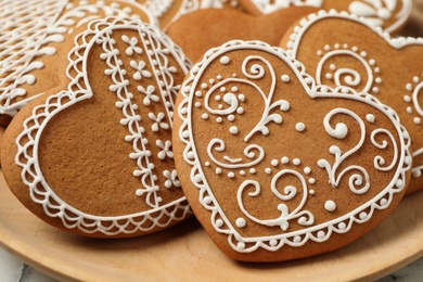 Photo of Tasty heart shaped gingerbread cookies in plate, closeup