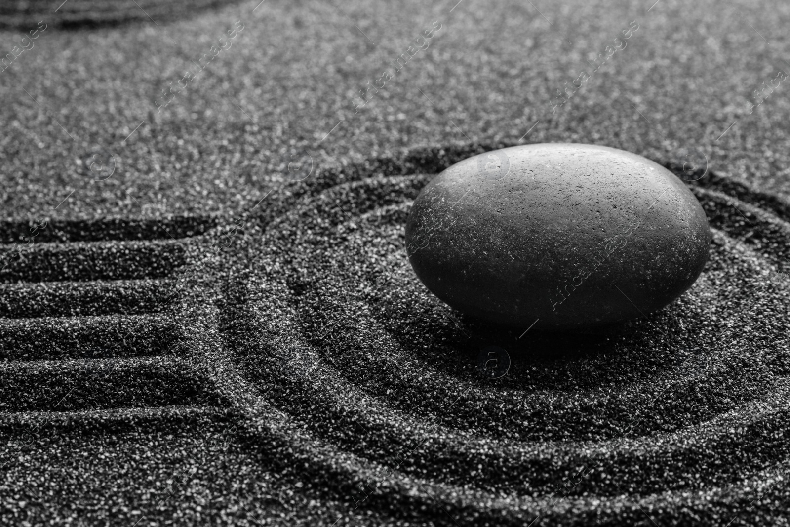 Photo of Black sand with stone and beautiful pattern. Zen concept
