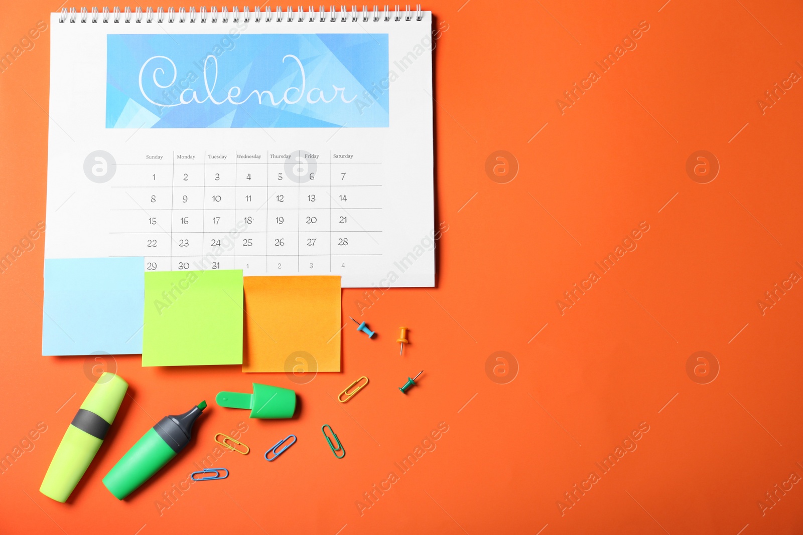 Photo of Calendar page and office stationery on orange background, flat lay. Space for text