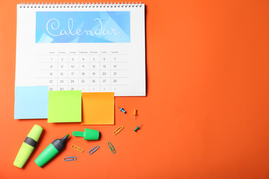 Photo of Calendar page and office stationery on orange background, flat lay. Space for text