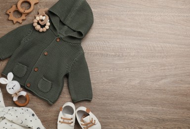Flat lay composition with baby clothes and accessories on wooden table. Space for text