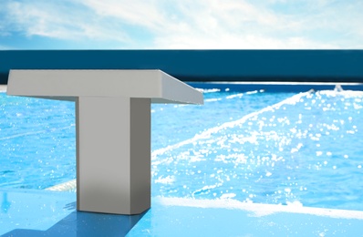 Photo of Starting platform near outdoor swimming pool on sunny day