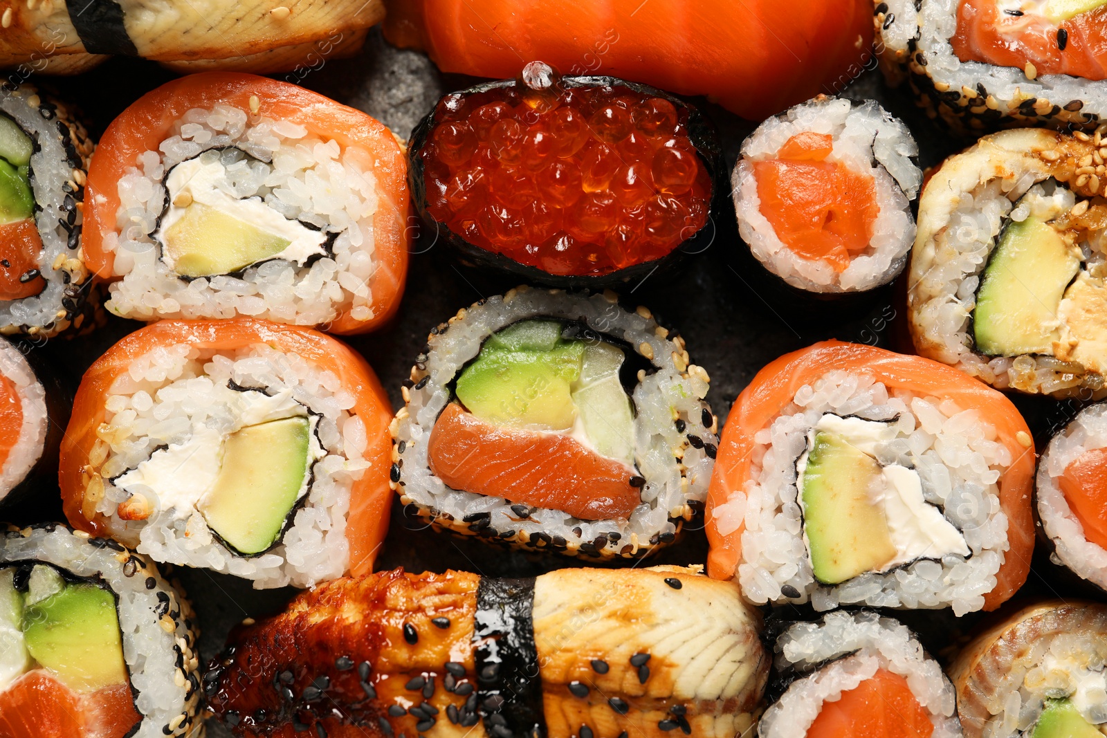 Photo of Different tasty sushi rolls as background, top view