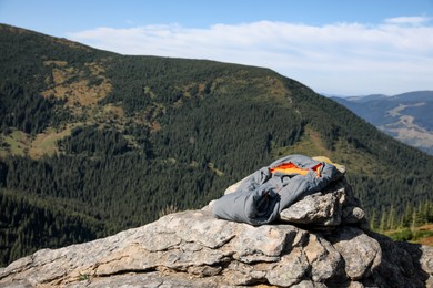 Photo of Sleeping bag on mountain peak, space for text