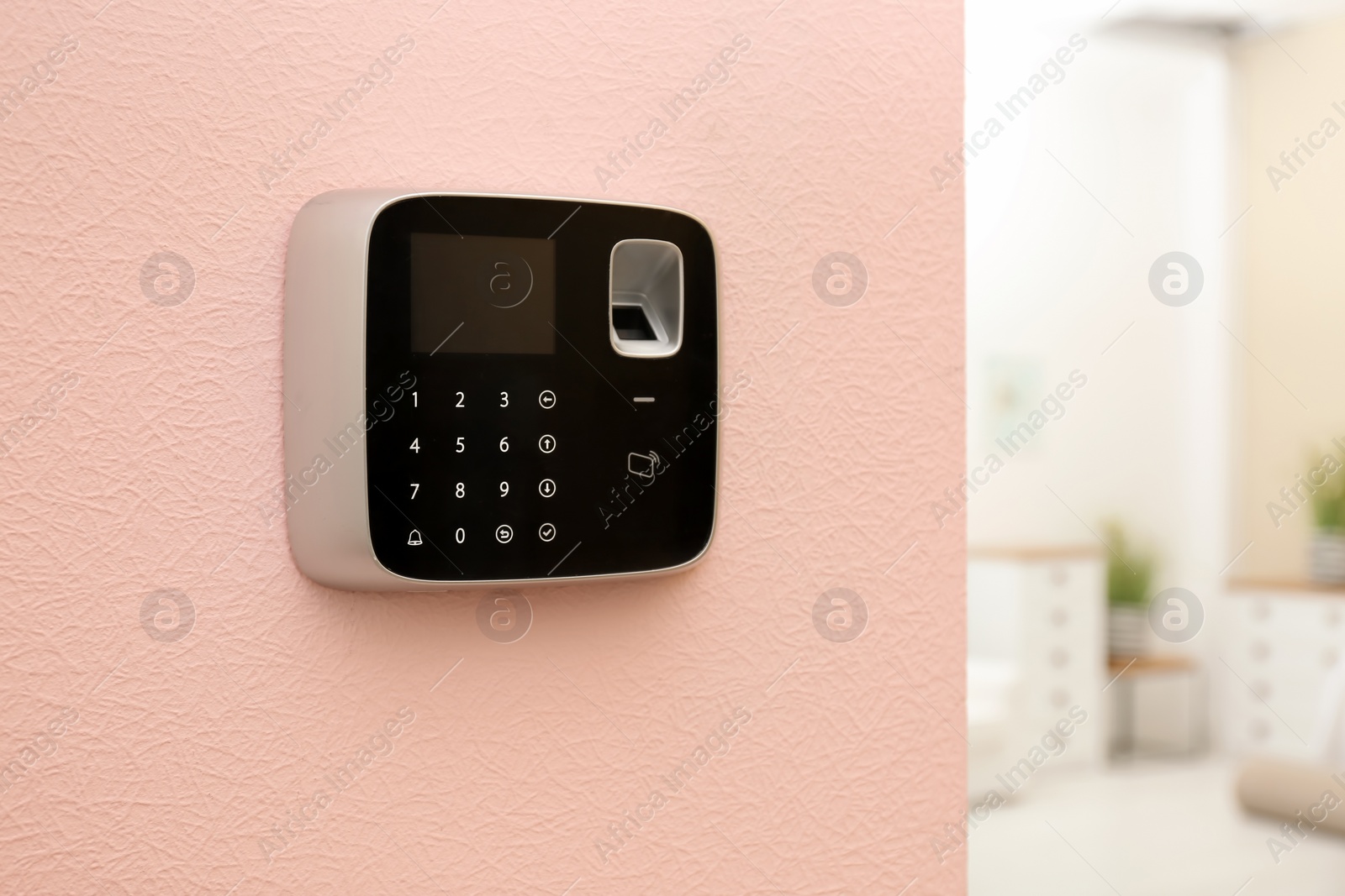 Photo of Modern alarm system with fingerprint scanner on color wall indoors. Space for text