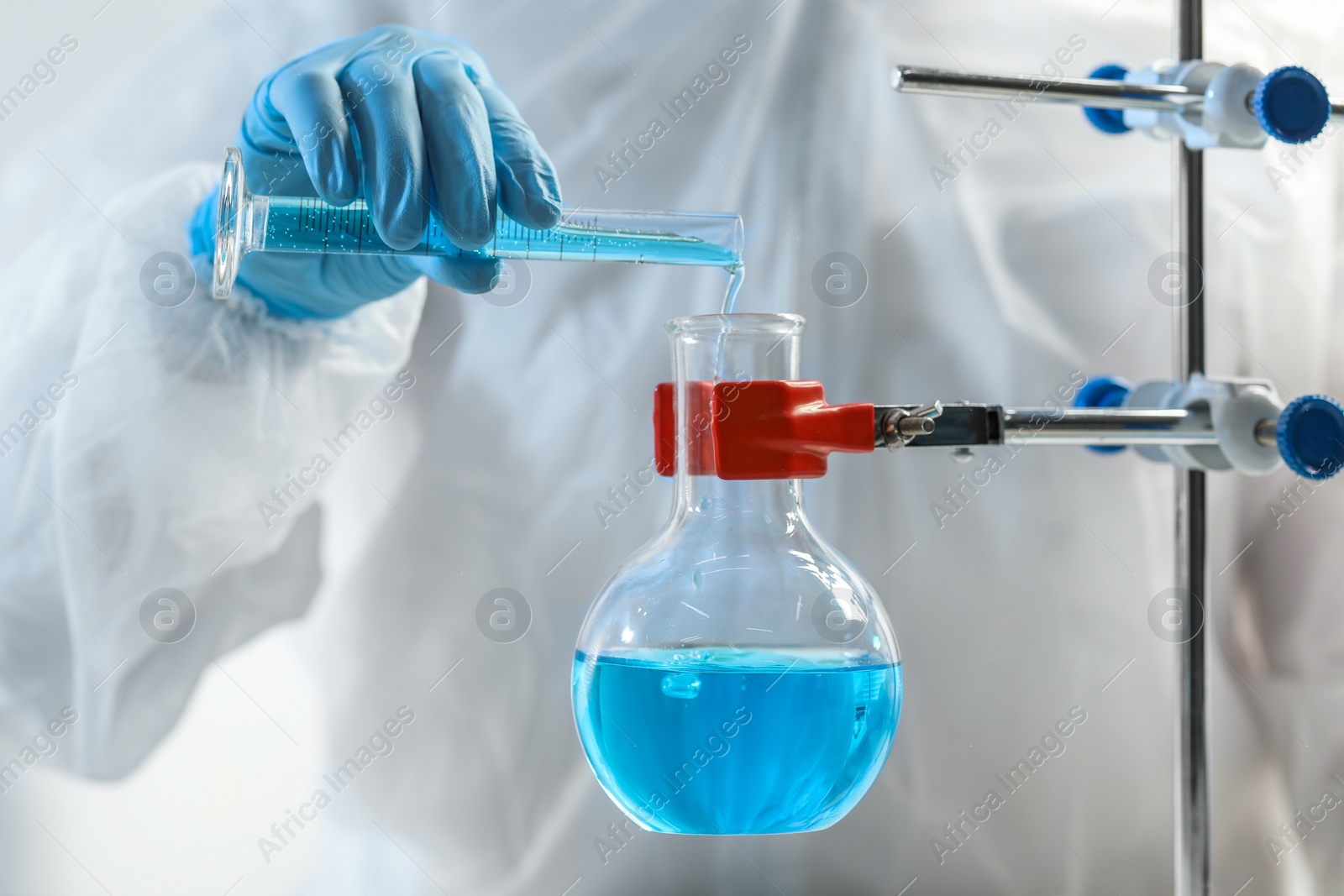 Photo of Scientist working with flask and test tube in laboratory, closeup