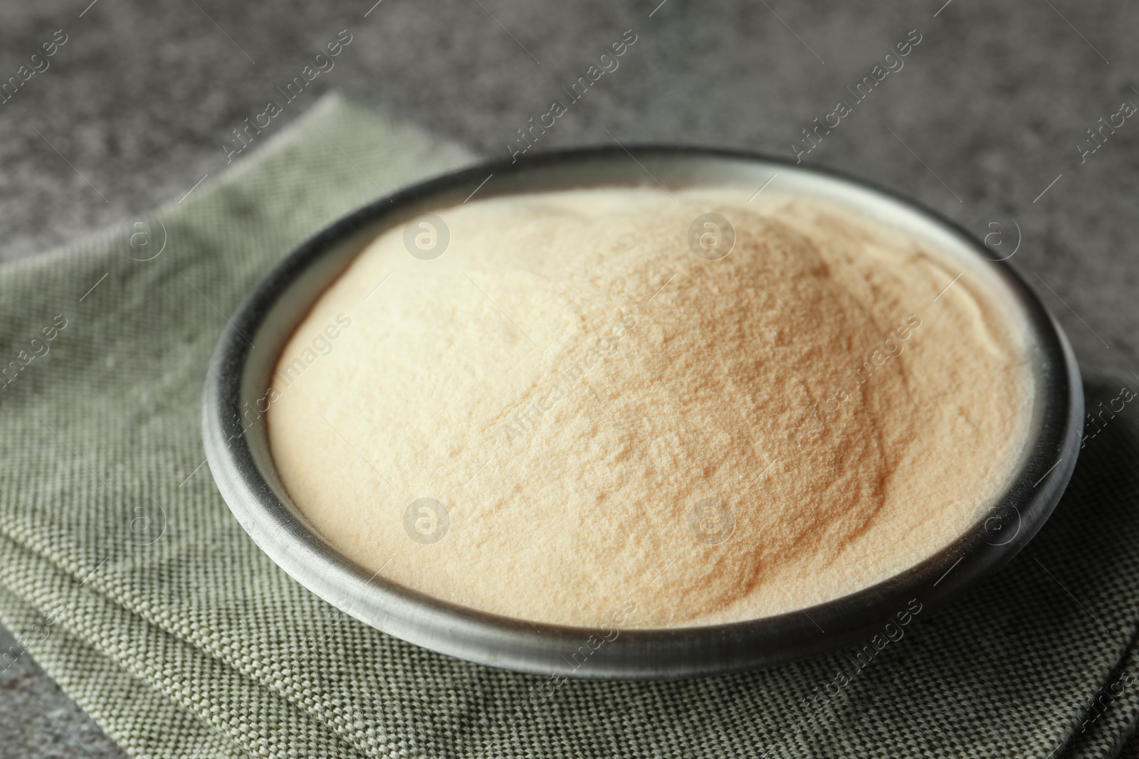 Photo of Bowl of agar-agar powder on grey table, closeup