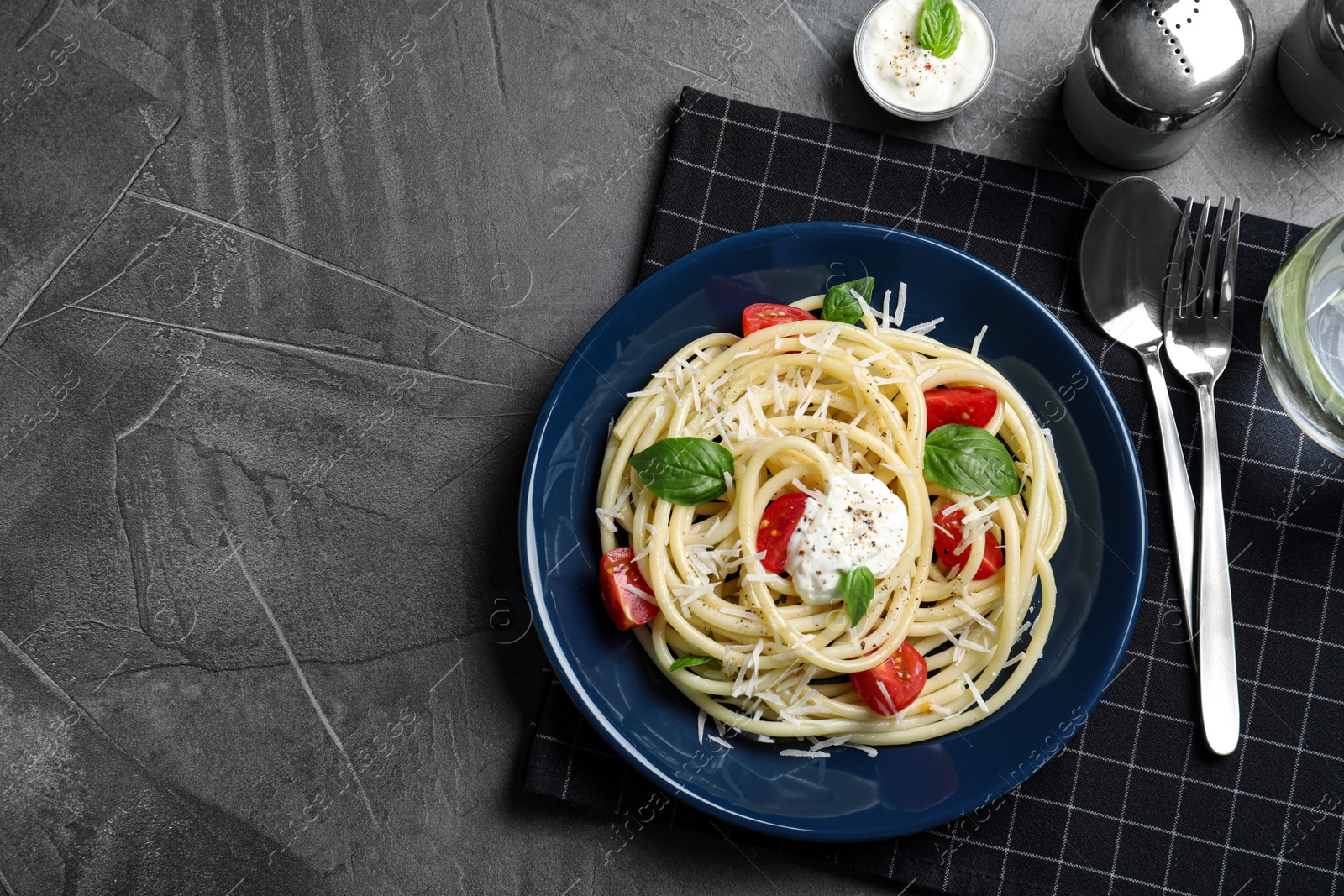 Photo of Delicious spaghetti with sour cream dressing on grey table, flat lay. Space for text