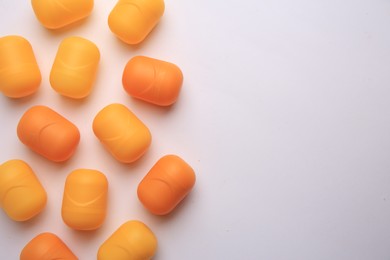 Photo of Sveti Vlas, Bulgaria - June 30, , 2023: Orange plastic capsules from Kinder Surprise Eggs on white background, flat lay and space for text
