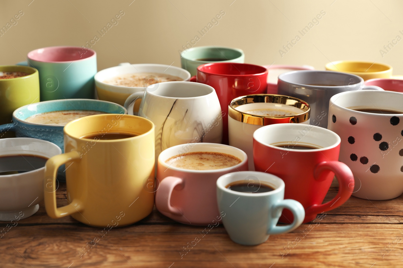 Photo of Many cups of different coffees on wooden table