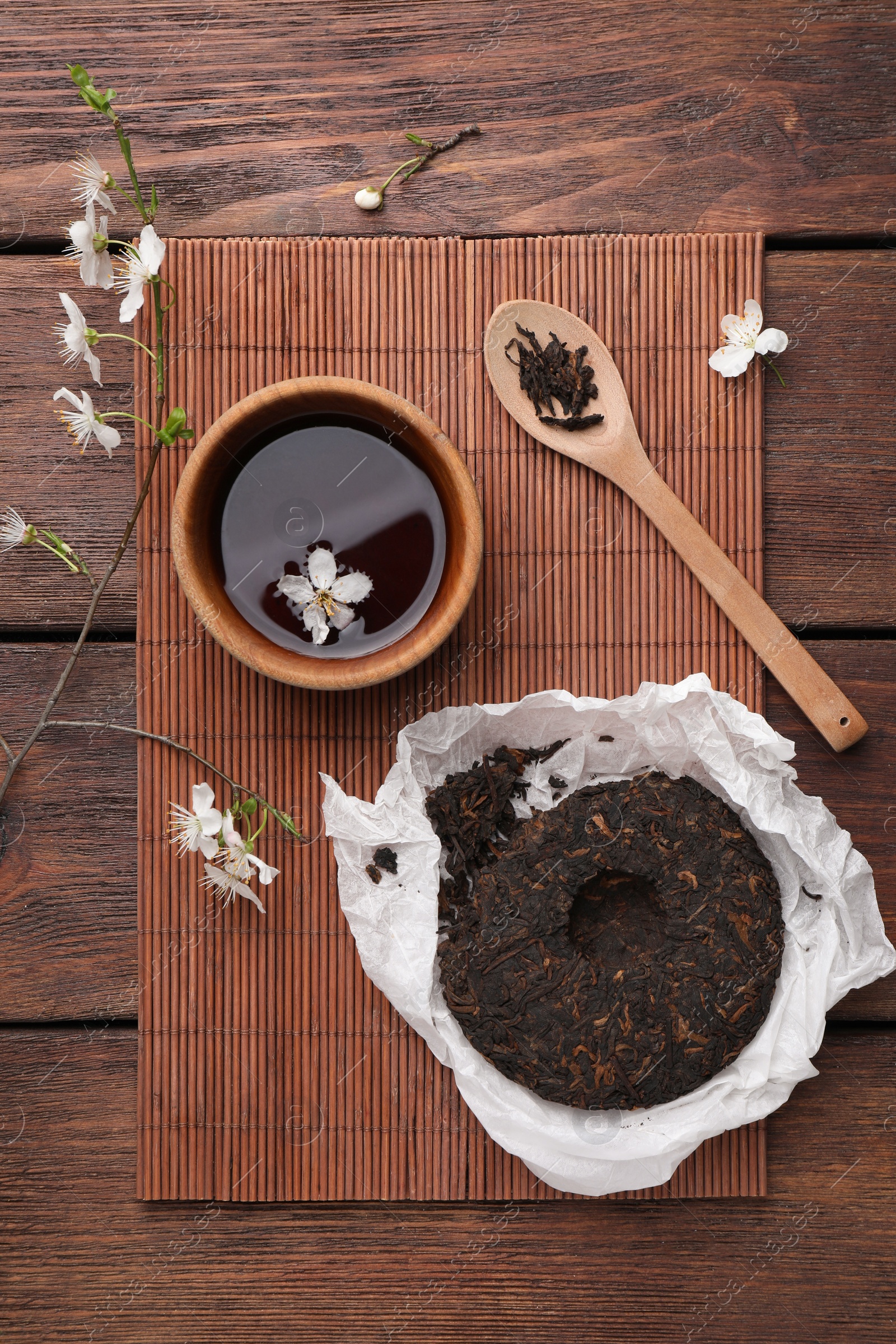 Photo of Flat lay composition with aromatic pu-erh tea on wooden table