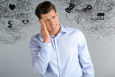 Stressed man with mess in his head on grey background